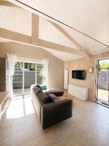 a living room with a couch and a tv at Chalet Familial 6 personnes in Gujan-Mestras