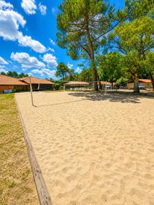 a sand volleyball court with a goal in a park at Chalet Familial 6 personnes in Gujan-Mestras
