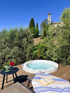 a hot tub sitting on a deck with a table at Stecadó Glamping in Dolceacqua