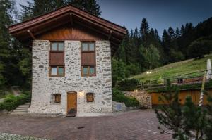 a small stone building with a wooden roof at Maso Noce Ovest in Mezzana
