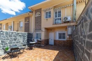 a house with chairs and a patio in front of it at Semi-detached Hse in Loeches