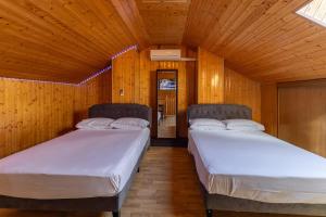 two beds in a room with wooden walls at Semi-detached Hse in Loeches +29 photos