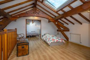a attic bedroom with a bed and a vaulted ceiling at Chez Lulu in Brézins