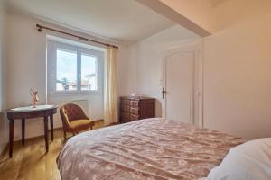 a bedroom with a bed and a table and a window at Chez Emile in Brézins