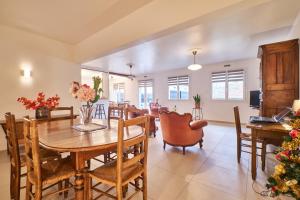 a dining room and living room with a table and chairs at Chez Emile in Brézins