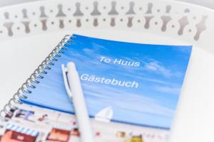 a spiral notebook with a book entitled to hilo gstaub at Ferienwohnung to Huus in Bensersiel