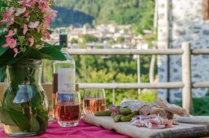a table with a bottle of wine and a plate of food at Maso Noce Ovest in Mezzana