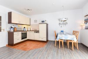 a kitchen and dining room with a table and chairs at Ferienwohnung to Huus in Bensersiel +16 photos