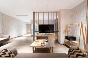 a living room with a couch and a tv at The Solith Hotel Managed By Nicecy in Ho Chi Minh City