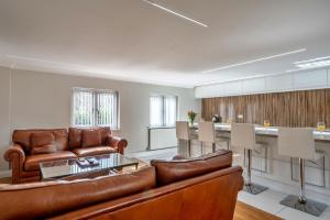 a living room with a couch and a kitchen at Finest Retreats - Hollies Coach House in Martock