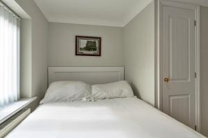 a white bed in a room with a window at Finest Retreats - Hollies Coach House in Martock