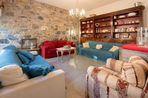 a living room with two blue couches and a stone wall at Casa Sole di Toscana USO ESCLUSIVO con 5 camere, 3 bagni, terrazza panoramica, giardino e vasca idromassaggio in Monterotondo