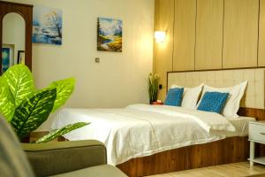 a bedroom with a bed with white sheets and blue pillows at Sea Turtles Guest House in Al Ḩadd +30 photos
