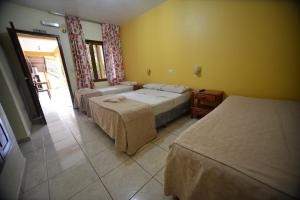a hotel room with two beds and a window at Hotel Lilian in Puerto Iguazú