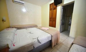 a small bedroom with two beds and a bathroom at Hotel Lilian in Puerto Iguazú