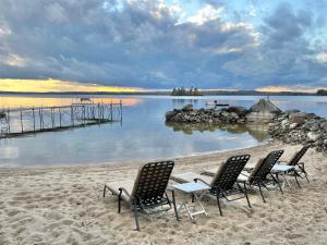 a group of chairs sitting on the beach at BEACHSIDE ON SEBAGO LIMIT 6 villa in Standish