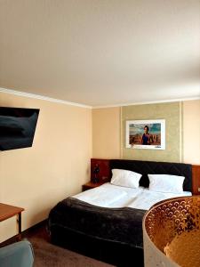 a hotel room with a bed and a chair at HOTEL SPECHT Tremonia Group - Dortmund in Dortmund