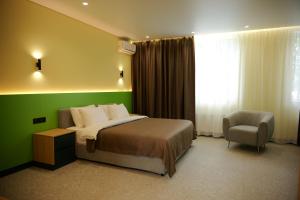 a hotel room with a bed and a chair at BVS Hotel in Ukrayinka