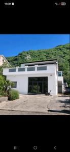 a white building with large windows and a mountain at Vila Brig 108 - private swimming pool and jacuzzi in Rijeka