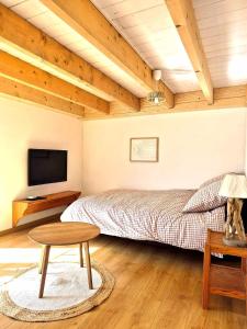 a bedroom with a bed and a table and a tv at Cozy Studio in Marck