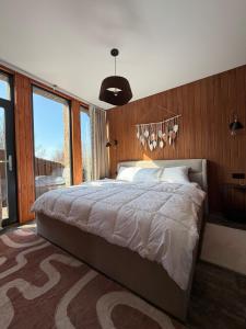 a bedroom with a large bed and a large window at Bruno House in Almaty