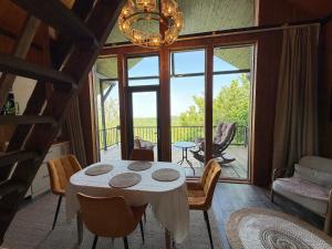 a dining room with a table and a balcony at Bruno House in Almaty