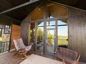 a screened in porch with two chairs and glass doors at Bruno House in Almaty