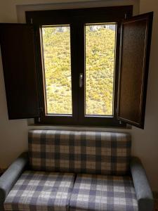 a couch sitting in front of two windows at Dimora Civita in Castelcivita