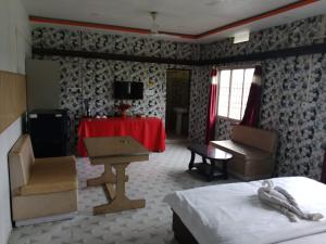 a bedroom with a bed and a table and a desk at countryside view hotel Silchar in Silchar