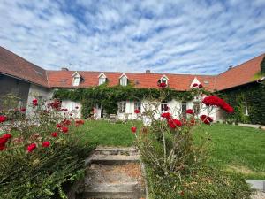 a garden with red flowers in front of a building at La Ferme de la Sensée in Gouy-sous-Bellonne +15 photos