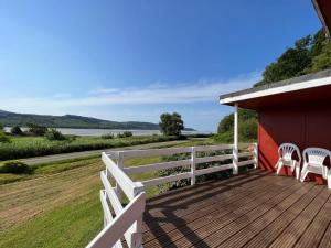 a porch with two chairs and a fence at Lochead Chalet 1 in Lochgilphead