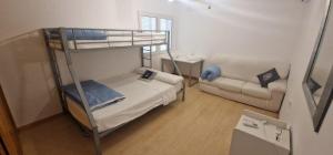 a small room with a bunk bed and a couch at Beachfront Villa in Moraira