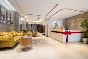 a lobby with yellow couches and a bar with a red ribbon at The Solith Hotel Managed By Nicecy in Ho Chi Minh City +128 photos
