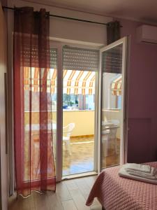 a bedroom with a sliding glass door to a patio at Barocco salentino Home in Lecce