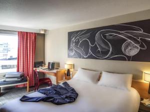 a bedroom with a bed and a desk with a computer at ibis Tours Centre Gare in Tours