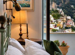 a bed with a view of a city from a window at Villa Positano with sea view ! in Positano