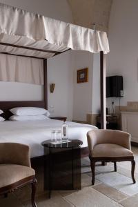 a bedroom with a bed and two chairs and a table at Dimora Mennuti in Monteparano +107 photos