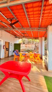 a room with a red table and yellow chairs at Beach and Hills Resort Diveager in Kārle
