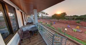 a balcony with a desk and a view of a field at Beach and Hills Resort Diveager in Kārle
