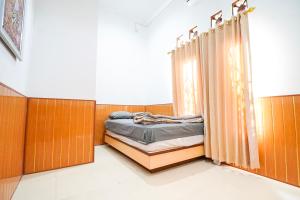 a bedroom with a bed and a curtain at Ndalem Artho in Beran-kidul