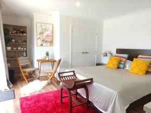 a bedroom with a large bed with a red rug at Private Cozy Sleepout with Free Parking & Self Check-in in Hamilton