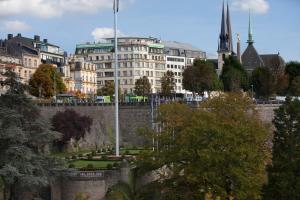 Blick auf eine Stadt mit einer Mauer und einem Gebäude in der Unterkunft Grand Hotel Cravat in Luxemburg (Stadt)