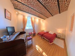 a bedroom with a bed and a desk with a computer at La Ferme de la Sensée in Gouy-sous-Bellonne