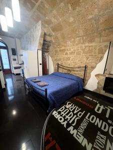 ein Schlafzimmer mit einem Bett und einer Steinwand in der Unterkunft Lu bobò in Alghero