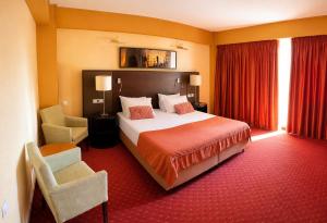 a hotel room with a bed and a chair at Boeme88 in Eforie Sud