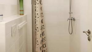 a bathroom with a shower with a shower curtain at Haus Eichenkrone in Bodstedt +9 photos