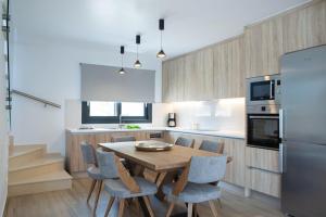 a kitchen with a table and chairs and a refrigerator at Amalfi Twins Villa in Nydri