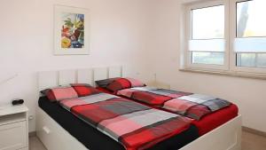 two beds in a white bedroom with two windows at Haus Eichenkrone in Bodstedt