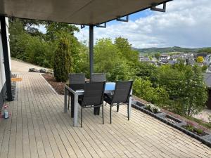a table and chairs sitting on a patio at Ferienwohnung Auszeit am Waldrand in Olpe
