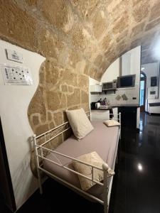 ein Bett in einem Zimmer mit einer Steinwand in der Unterkunft Lu bobò in Alghero